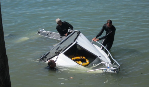 The rescued boat is manouvered into position on the wharf boar ramp. Image Sue Morrow