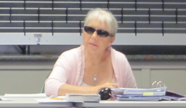 Linda Cole with eyes protected by drak galsses, chairing a Raglan Community Board Meeting