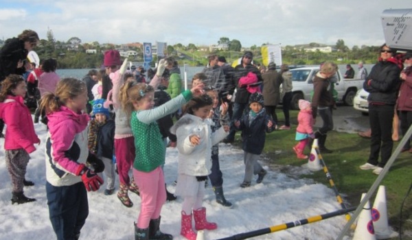 Kids enjoy fresh snow from a snow making machine at 'Snow on the Beach'