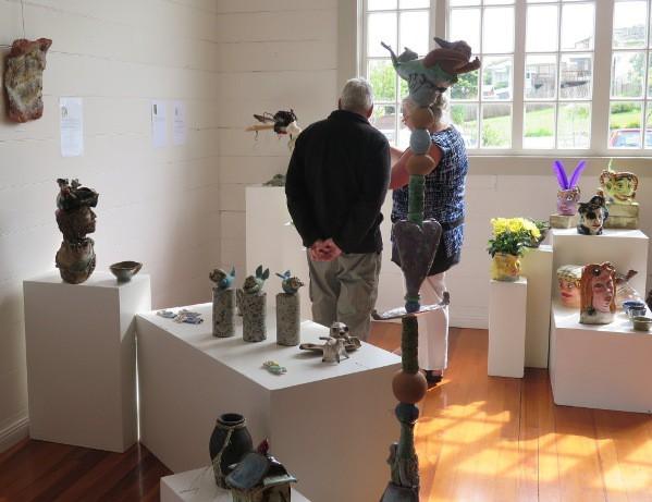 Visitors studying the clay art at the exhibition