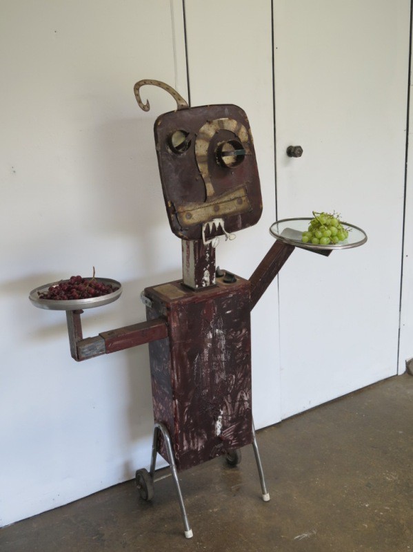 Robot steel sculpture welcomes visitors with plates of grapes at the Studeo Gallery