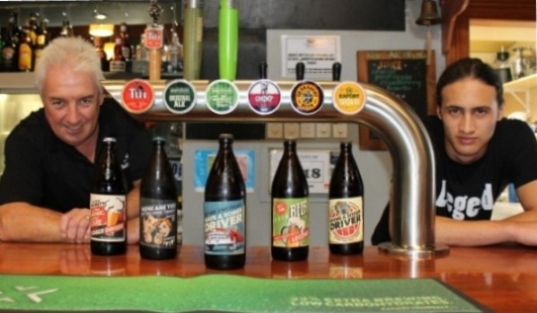 Harbour View Hotel owner Jeff Holloway, left, and bartender Jacob Jespersen are pleased that the retro-style stickers on quart-size beer bottles are generating positive conversations. - Image supplied