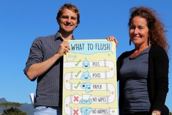 Raglan graphic designer Leighton Davies and Raglan Ward Councillor Lisa Thomson show an example of a poster produced for Waikato District Council’s wastewater system public education campaign. Image WDC