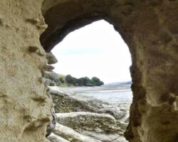 Arch rock formation on shore of Aotea Harbour